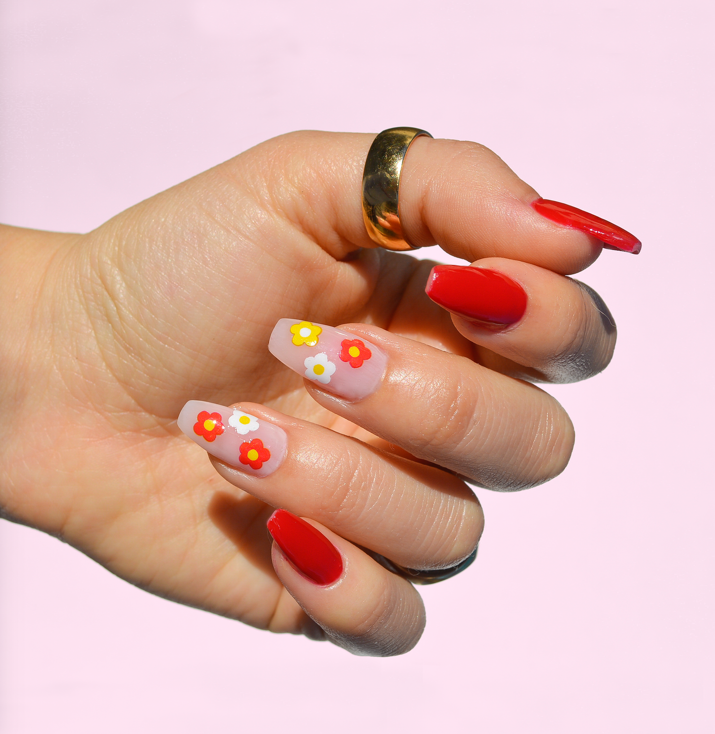 red nail polish look with 2 accent nails showing yellow red and white flowers