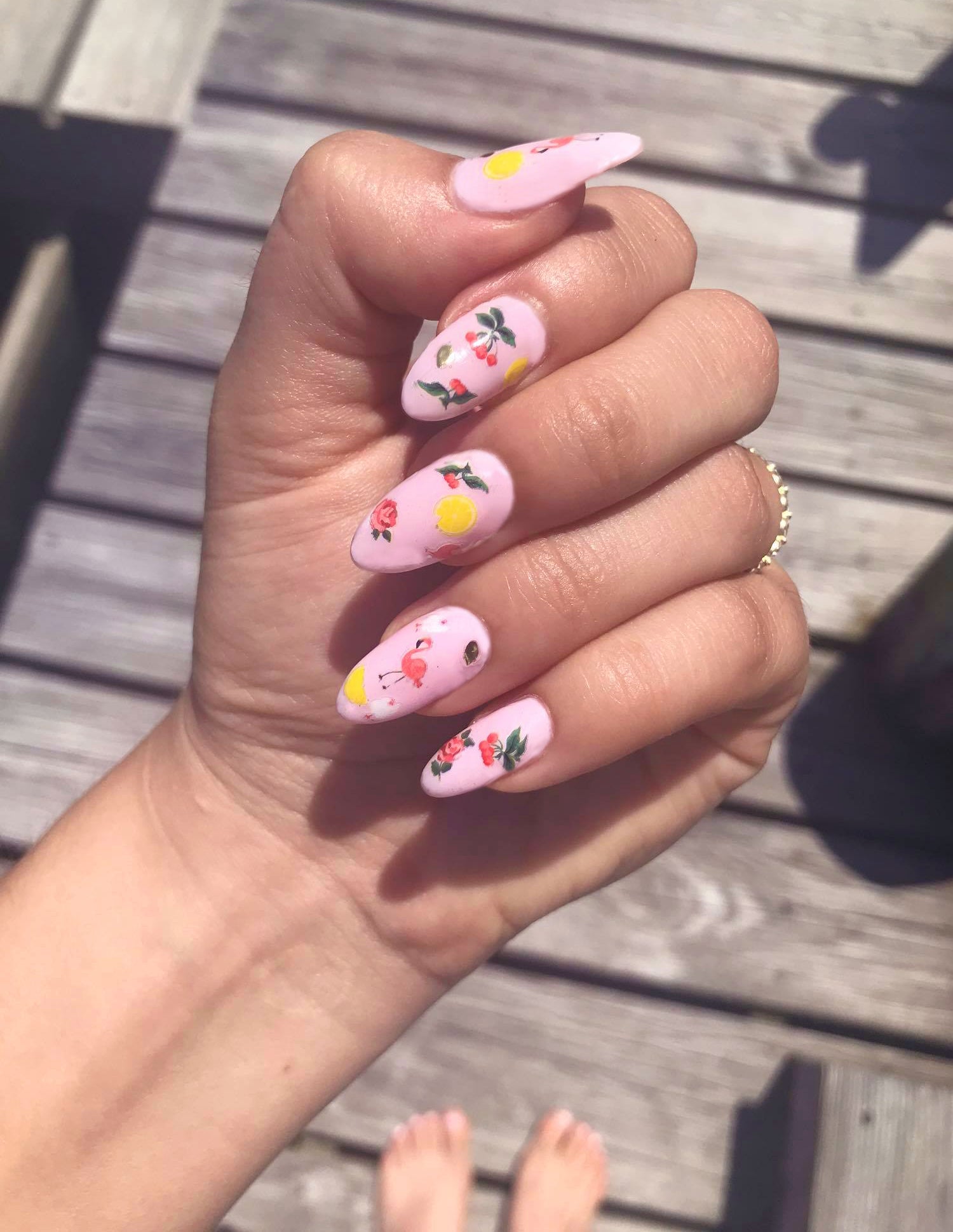 pink nail polish with flamingos, cranberries, lemons, gold accent sticker art