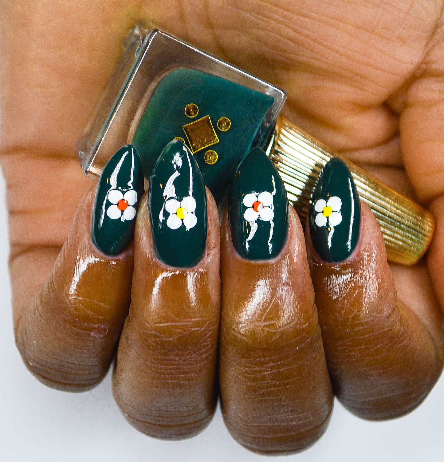 dark green nail polish with white flowers stickers